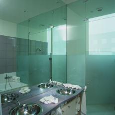 Clean, Contemporary Bathroom Features Stainless Steel Sinks