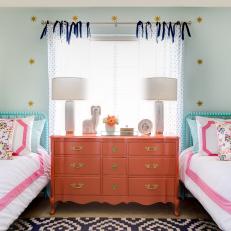 Girl's Bedroom With Coral Dresser and Light Blue Accent Wall 