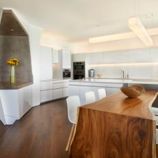 Modern Eat-In Kitchen With Natural Wood Table, White Cabinetry and Cube Fixtures 