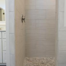 Gray Tile Shower Boasts Beautiful Pebble Tile Floors