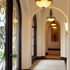 Neutral Archway Hall With Decorative French Doors and Traditional Light Fixtures 