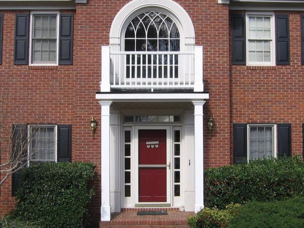 Traditional Brick Home With White Portico and Red Front Door