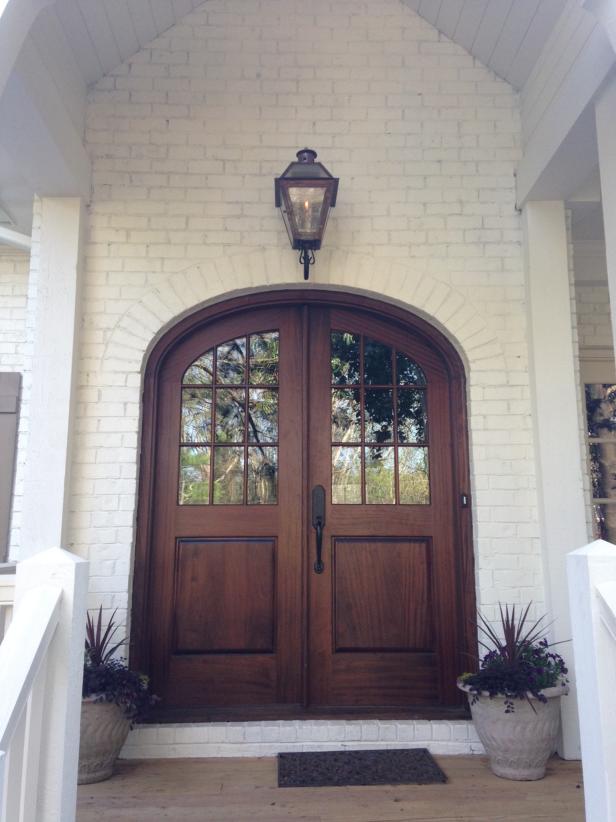 Arched Wooden Doors in White Brick Entry