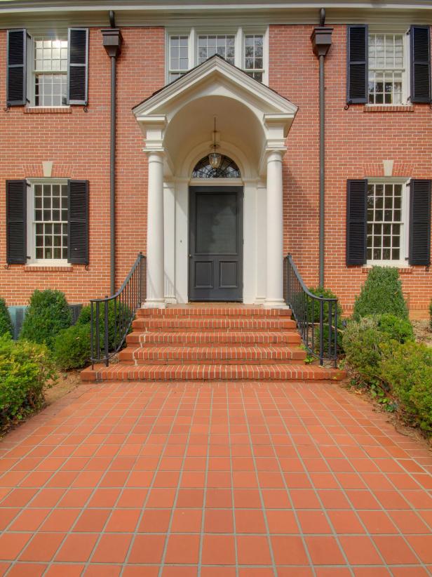 Traditional Brick Home With Portico and Black Front Door