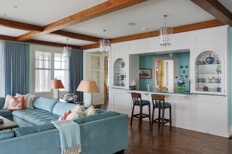 Coastal Room With Blue Sectional, Arched Built-Ins, Glass Pendants
