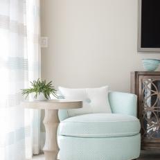 Blue Swivel Chair With Neutral Side Table and Sheer Curtains 