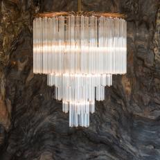 Feminine Glass Chandelier Hanging in Front of Large Quartzite Panel 