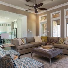 Contemporary Beige Living Room With Sectional, Tufted Coffee Table and Blue Patterned Chairs