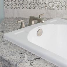 Contemporary Bathroom Sink Features Gray Stone Countertop & Nickel Faucet