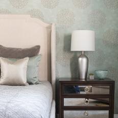 Soft Green Bedroom Features Neutral Upholstered Bed Frame and Mirrored Nightstand