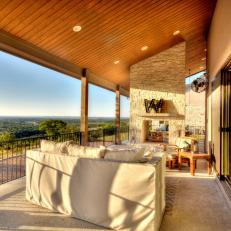 Covered Porch With Scenic Outdoor View and Tall Stone FIreplace 