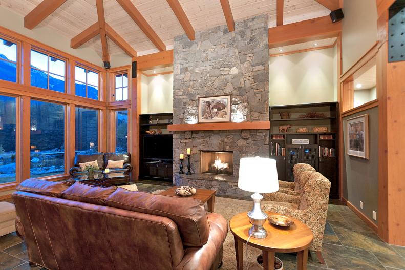 Neutral Living Room With Gray Stone Fireplace and Exposed Beam Ceiling
