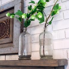 Fixer Upper: Antique Jugs with Flowers Decorate Wood Mantel 