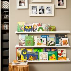 Nursery Reading Area With Floating Bookshelves & Framed Portraits