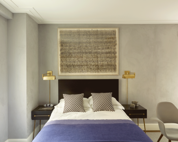 Gray Bedroom With Gold Sconces Flanking Wood Headboard
