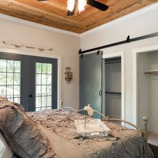 Main Bedroom With Wood-Paneled Ceiling and Sliding Barn Closet Doors