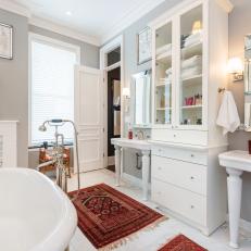 Bright, White Transitional Bathroom With Split Vanities and Red Accent Rugs 