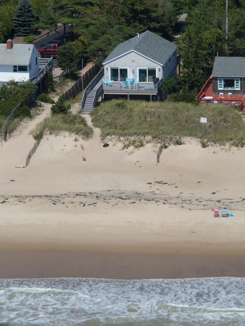 Aerial View of Small Cape Cod Beach Home With Wraparound Deck