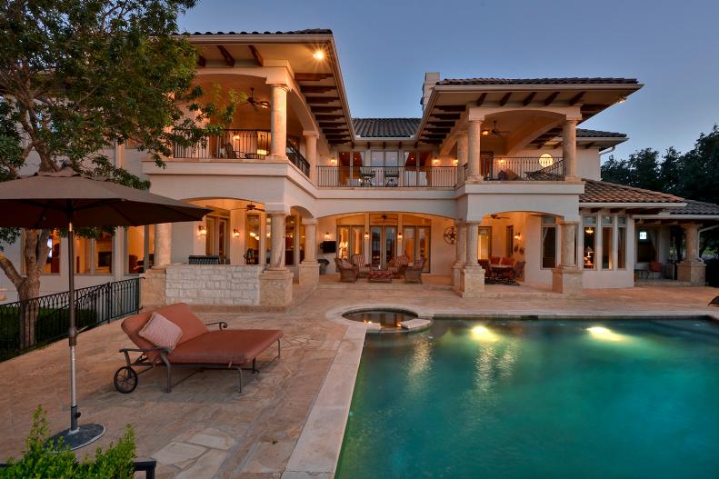 Back Exterior of Mediterranean Home With Swimming Pool and Patio