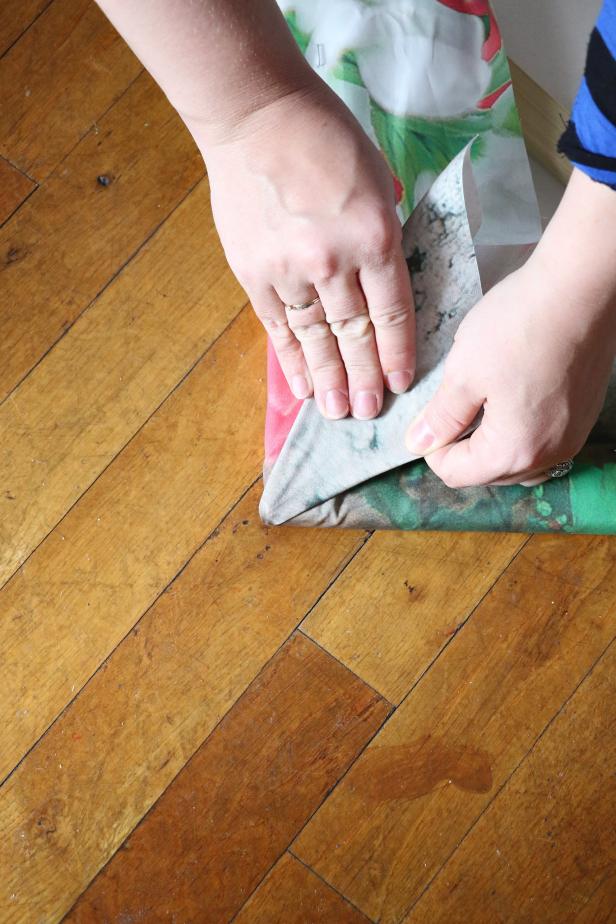Hold the corner straight up in the air and flatten the fabric down to create a triangle. This will make a clean corner. Staple in place.
