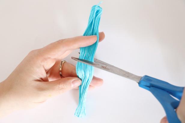 Cut the whole skein of embroidery floss in half.