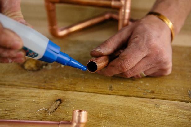 Apply contact cement to copper piping pieces to make a one-of-a-kind candelabra.