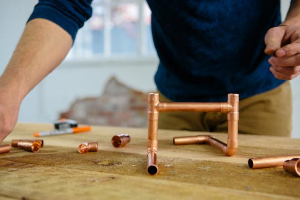 Shape copper piping into a base to make a one-of-a-kind candelabra.