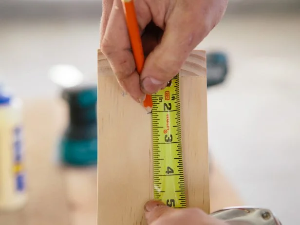 Measure two inches down from the top of the shelf, and mark for the hanging loop.