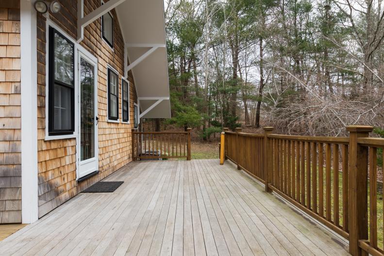 Wood Cottage Exterior with Deck and Evergreen Landscape