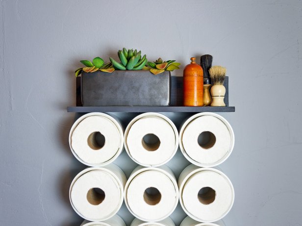 Repurposed plumbing fixtures make modern storage for your toilet tissue or other bathroom accessories.
