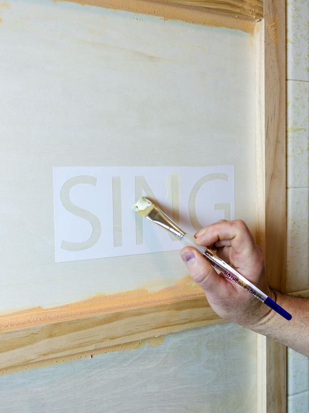 Apply the shelf paper template where you want the word or phrase to go on the wall. Use wood glue to paint the inside of the template. The wood glue will prevent the stain from penetrating the plywood. Allow the glue to dry completely before proceeding.