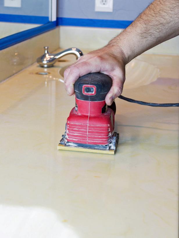 Sand the entire surface with 150-grit sandpaper. Use the sander for large areas and your hands for the basin and hard to reach spots. This step is critical to give the concrete something to grab when applied. Dust the surface with a damp cloth and allow to dry before proceeding.