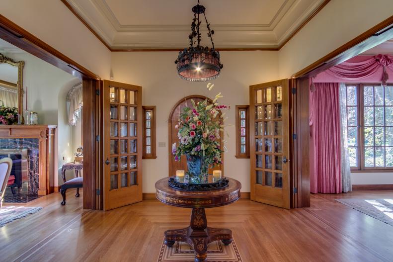 Neutral Foyer With Hardwood Floor, French Doors & Round Wood Table