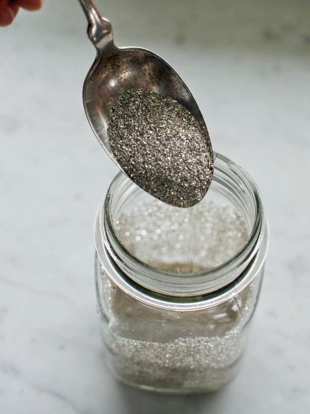 Immediately sprinkle glitter onto wet glue using a spool. Roll the jar around to allow glitter to coat all of the areas where glue was applied.