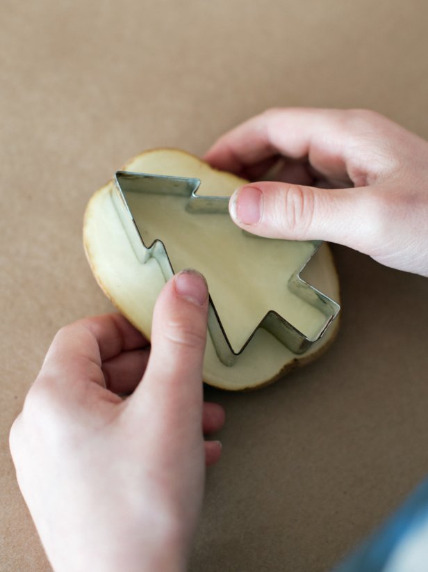 Press metal cookie cutter into the potato and cut around the cookie cutter.