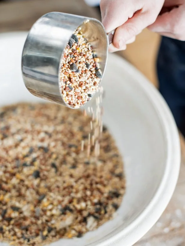 Scoop birdseed mixture into cookie cutter and press in until tightly packed. Smooth on top. Cut straw into 2' pieces. Insert a straw in each ornament to make a hole to later thread a piece of twine through. Make sure the straw a pushed all the way through and has enough birdseed around it to hold when hung.