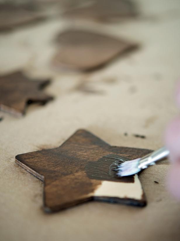 Lightly sand wooden ornaments with fine sand paper (220 grit) to smooth the rough edges. Paint ornaments with two coats of brown acrylic paint. All paint to dry.