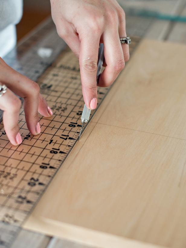 Use a craft knife to cut an outline of 1/2&quot; thick lines along drawn tic-tac-toe board. This cut edge will prevent wood stain from seeping into the grain, blurring the lines of the board.