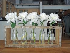 Create a one-of-a-kind centerpiece with recycled glass bottles, a wood plank and gold paint.