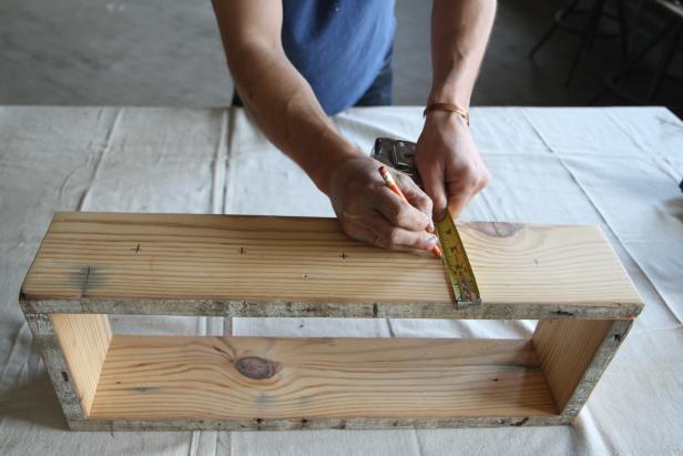 Measure vertically on wood centerpiece base, and make a mark where the bottles will go.