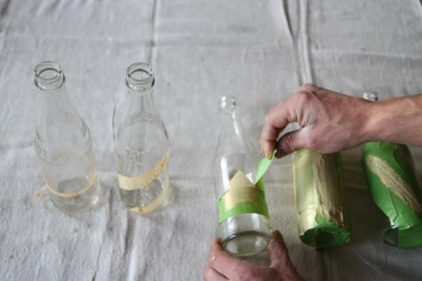 After paint dries, slowly remove painter's tape from glass bottles.