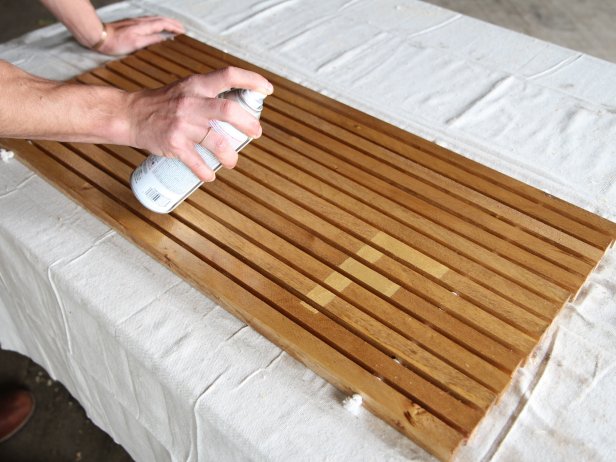 Dan Faires spraying wood doormat with clear polyurethane