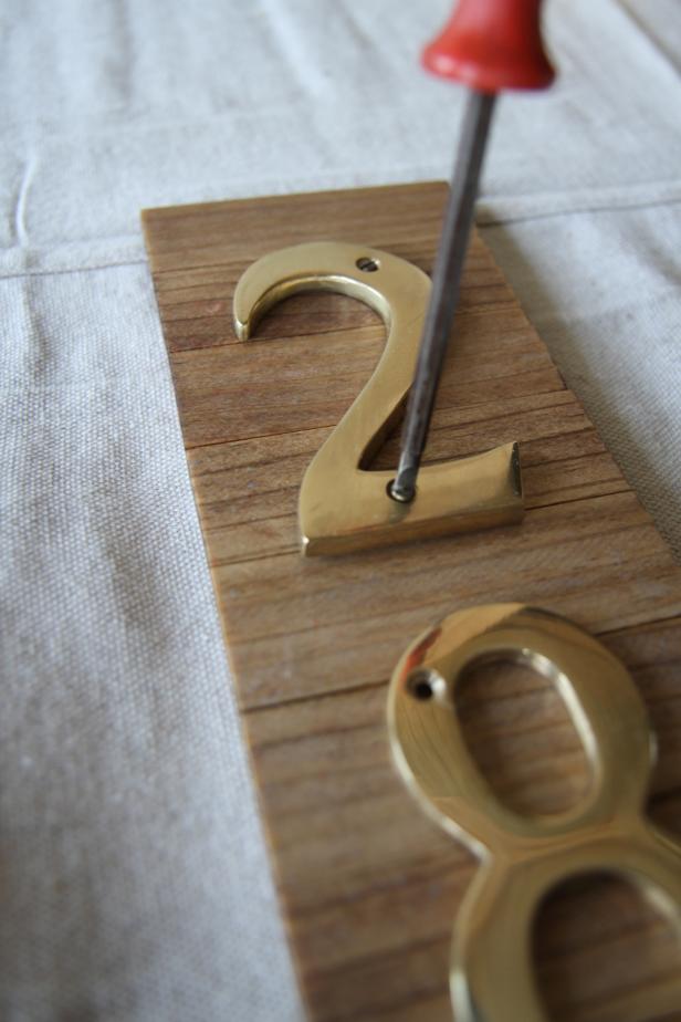 Dan Faires attaching house numbers with screws