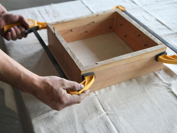 Hold wood frame together with bar clamps.