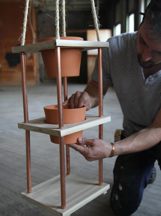 Dan Faires placing terra cotta pots inside wood pieces