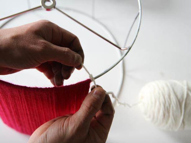 Attach the second yarn color to the lampshade by tying a knot before wrapping.