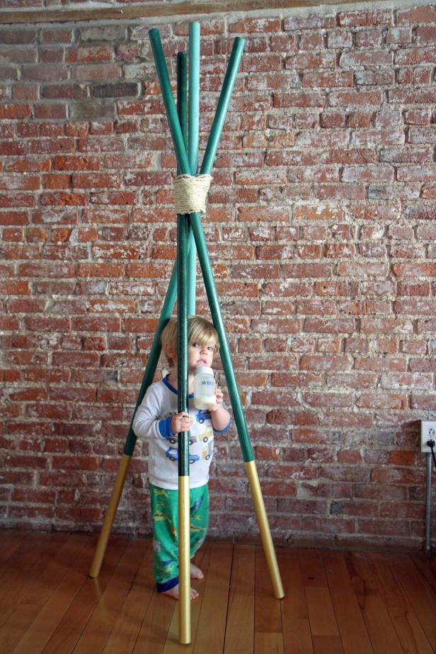 little boy with green and gold coat rack