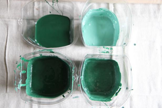 Create four different shades of green paint by adding hunter green paint to four containers, and adding different amounts of white paint to each of three of the containers.