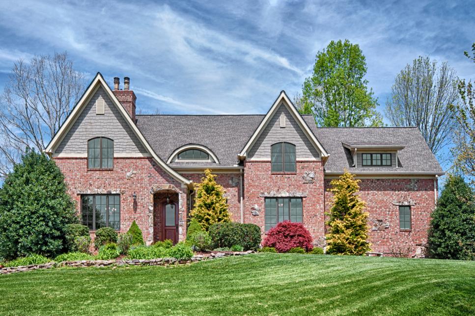 Tudor-Style Home Boasts Of Stunning Brick, Gray Shingle and Rolling Landscaping
