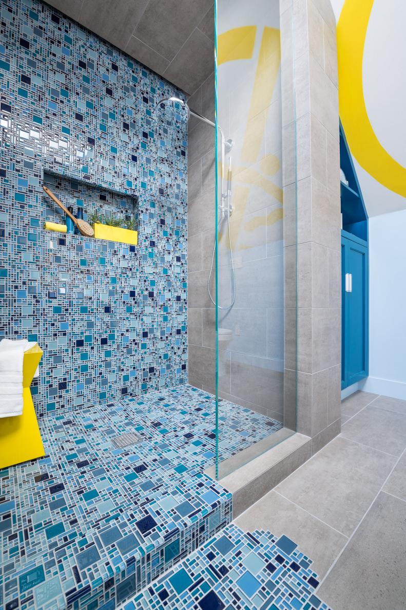 Shower With Blue Mosaic Tile Spilling Out Onto Floor for Pooling Effect